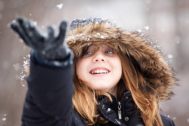 istock Beautiful Young Girl Catching Snowflakes 462576687