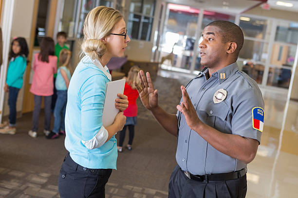 istock Teacher discussing saftey procedures with security officer in elementary school 462576773