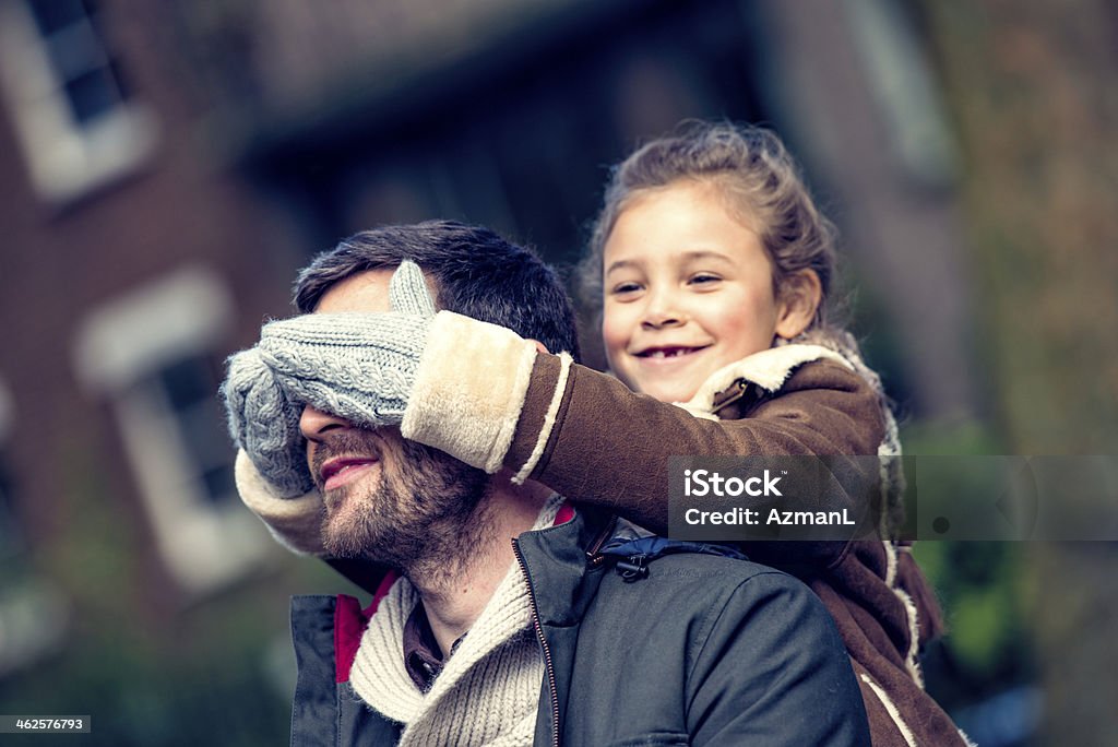 Guess who is! Father and daughter having fun in a park on a cold autumn day. Winter Stock Photo