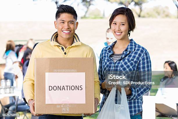 Pareja Joven Asiática Trabajo Voluntario Para La Donación En Automóvil Al Aire Libre Foto de stock y más banco de imágenes de Caja de donaciones