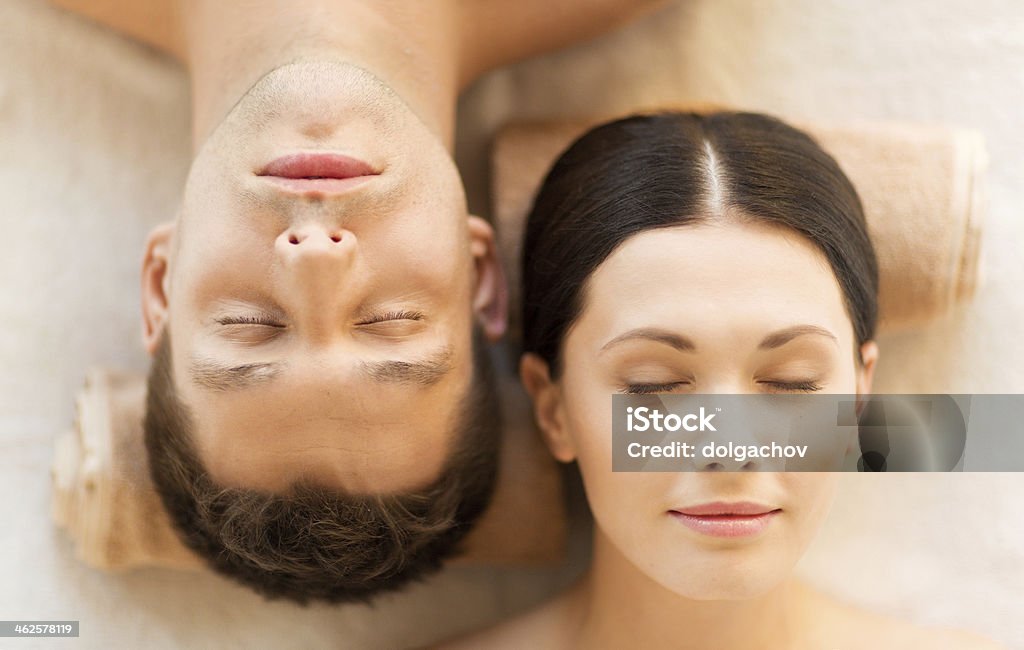 close up of happy couple faces in spa picture of couple in spa salon lying on the massage desks Couple - Relationship Stock Photo