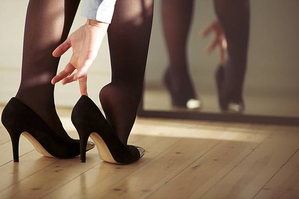 Young female wearing high heels Closeup of a young woman legs wearing high heel shoes in front of mirror at home. Young female getting dressed indoors. pantyhose stock pictures, royalty-free photos & images