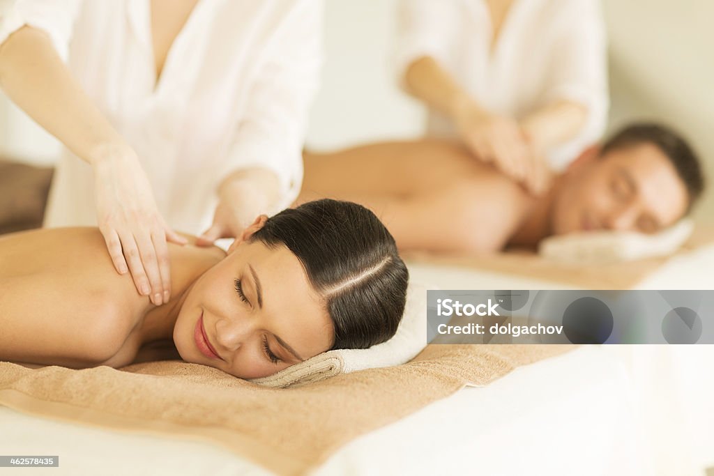 happy couple in spa salon having massage people, body care and relax concept - happy couple in spa salon lying on desks and having massage  Couple - Relationship Stock Photo