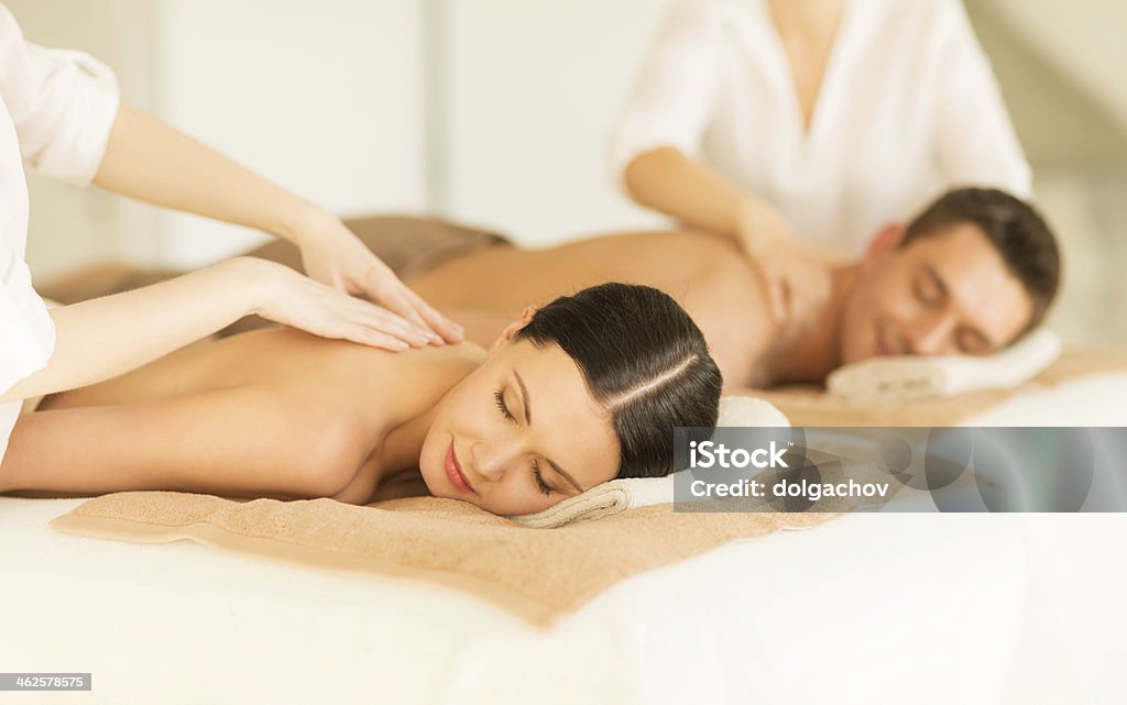 happy couple in spa salon having massage people, body care and relax concept - happy couple in spa salon lying on desks and having massage  Couple - Relationship Stock Photo