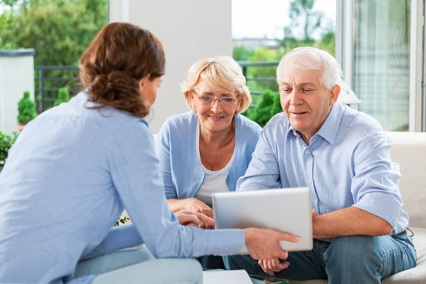 coppia senior parlare con un agente assicurativo - consultant explaining computer home interior foto e immagini stock