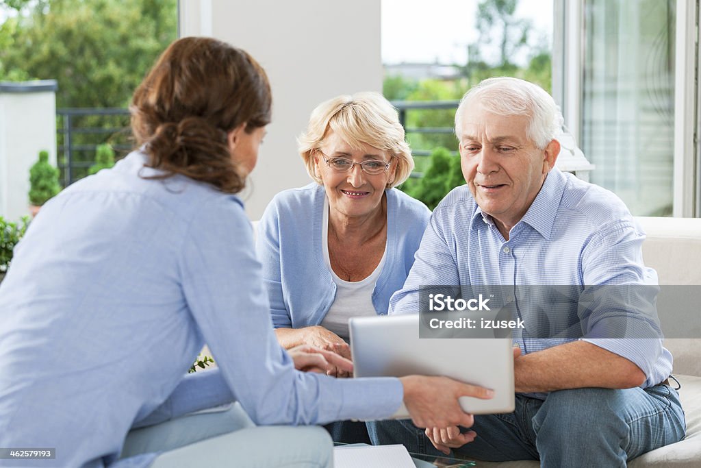 Senior couple talking with insurance agent Senior couple having meeting with financial advisor or insurance agent at home. Senior Adult Stock Photo
