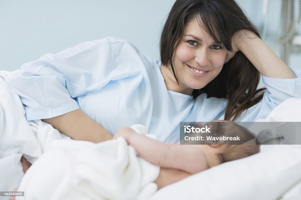 Sorridente mãe com seu bebê em uma cama - Royalty-free 30-39 Anos Foto de stock