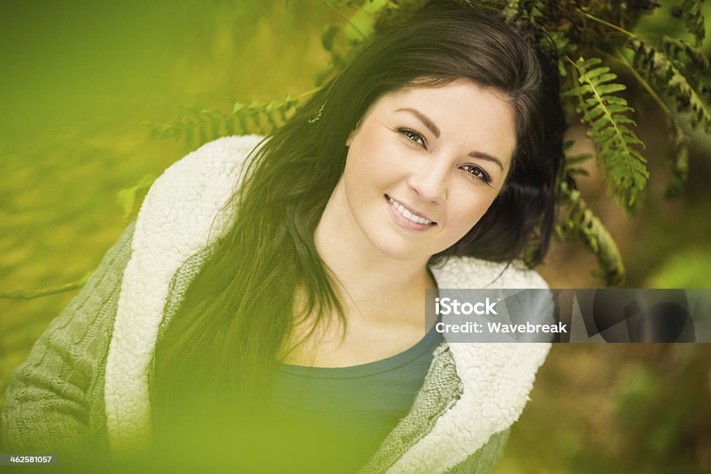 Rilassato allegro donna sdraiata su un ramo - Foto stock royalty-free di Abbigliamento casual