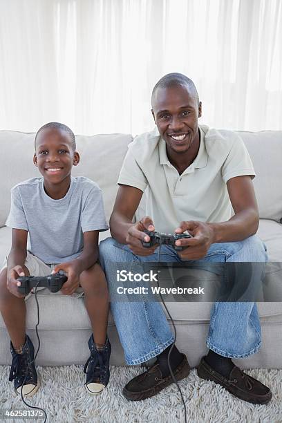 Lächelnd Sohn Und Vater Spielen Von Videospielen Zusammen Stockfoto und mehr Bilder von Afrikanischer Abstammung