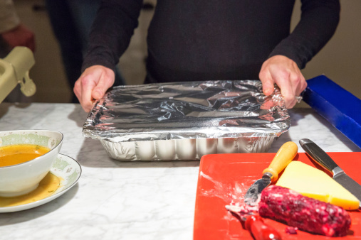 A women is putting away leftovers from a Thanksgiving day feast.  RM