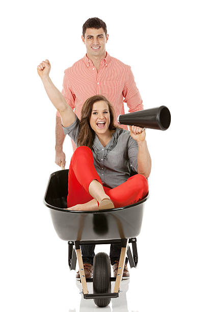 istock Man giving woman ride in wheelbarrow 462582607