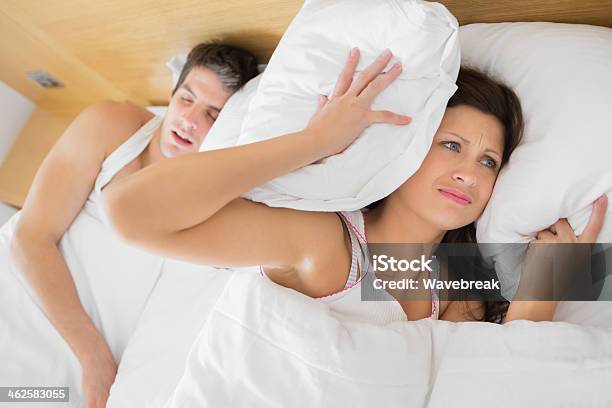 Annoyed Woman Trying To Block Out Partners Snoring Stock Photo - Download Image Now - 20-29 Years, Adult, Adults Only