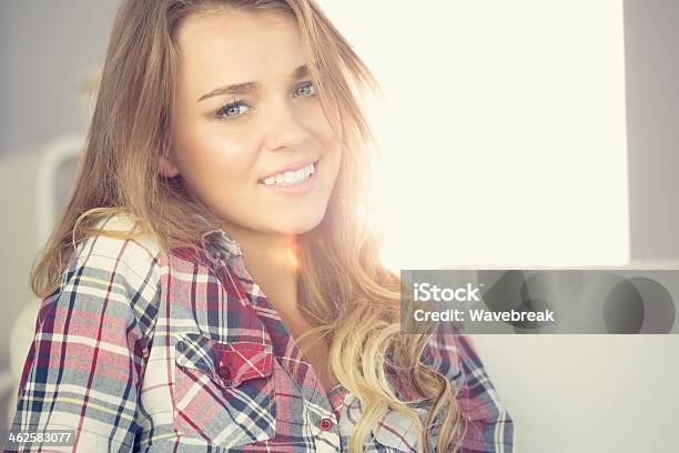 Cute Cheerful Young Woman Sitting On Couch Stock Photo - Download Image Now - Adult, Adults Only, Apartment