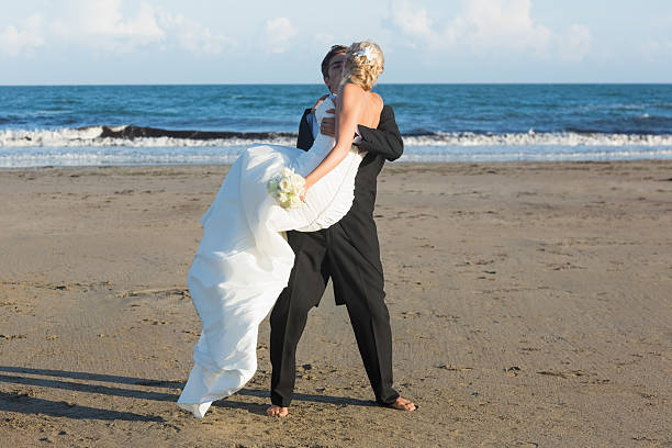 istock Dynamic young bridegroom lifting and kissing his charming wife 462583929