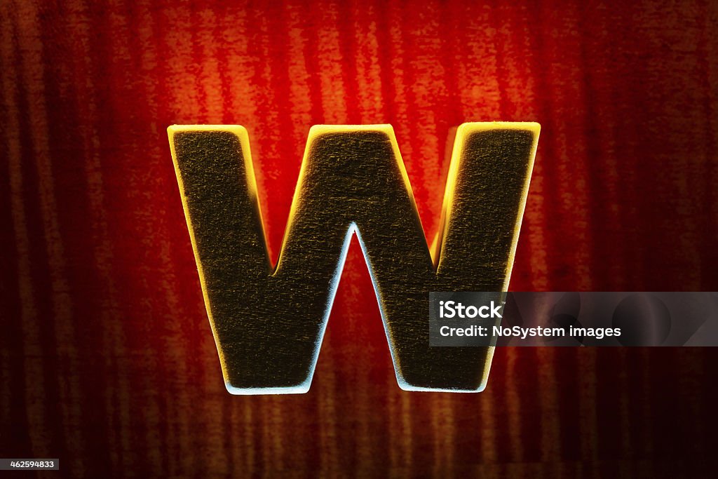 Wooden letter W Silhouette of wood letter W on red wood background Alphabet Stock Photo