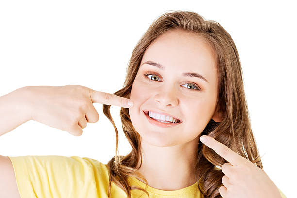 teen menina a apontar para os dentes perfeitos - teenager body care adolescence human lips imagens e fotografias de stock