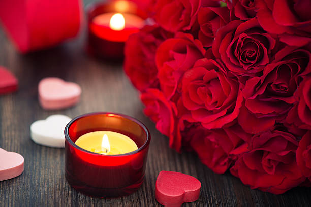 istock Red roses, mini hearts and candles on wooden background 462601765
