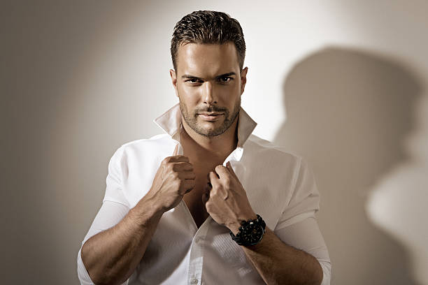 istock sexy male model buttoning shirt 462602663