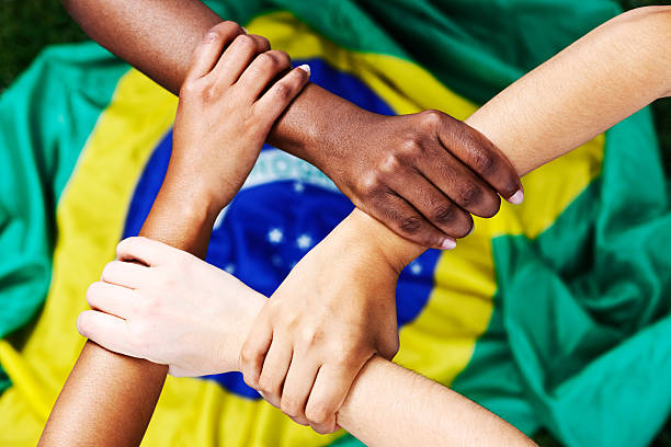 istock Four hands clasped in supportive square with Brazilian flag 462603371