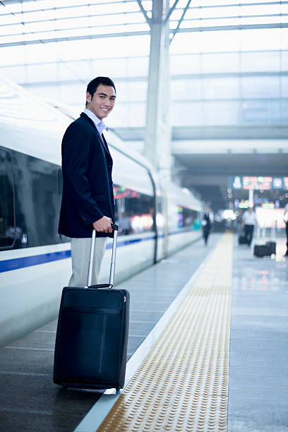 istock Businessman standing with a suitcase on the railroad platform 462604485