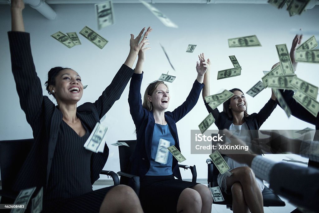 Business people with arms raised throwing money in the air Currency Stock Photo