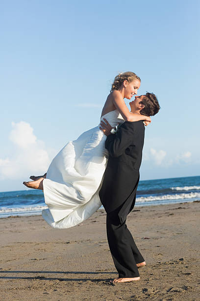 istock Dynamic lovely young bridegroom lifting his pretty wife 462617403