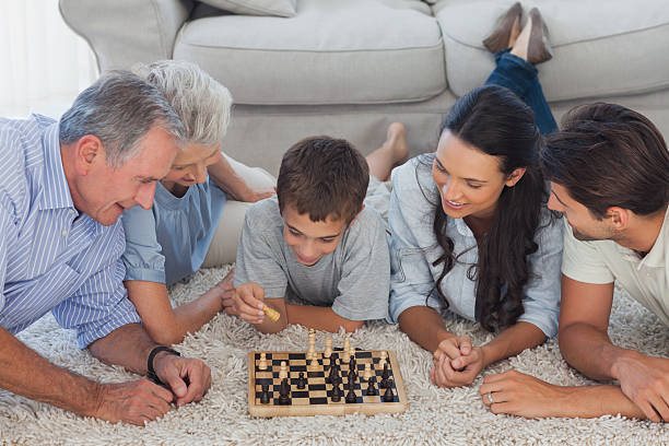 istock Family playing chess lying on a carpet 462618021