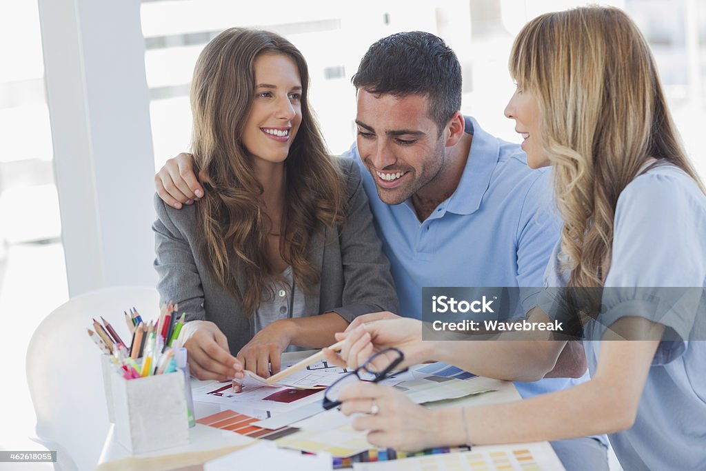 Hermosa pareja discutiendo con un diseñador de interiores - Foto de stock de 20 a 29 años libre de derechos