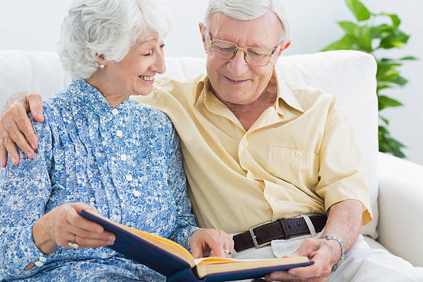 istock Aged couple watching photo album 462618301