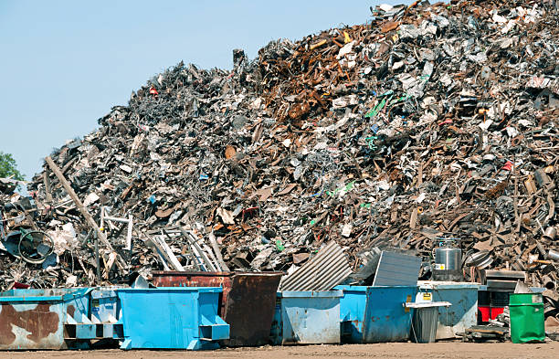 istock Piled scrap metal and dumpsters at recycling plant 462628603