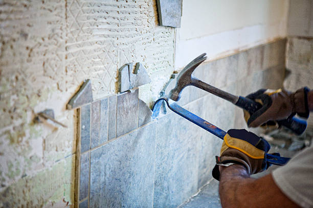 Home Renovations Man removing tile out old kitchen during home renovations. demolishing stock pictures, royalty-free photos & images