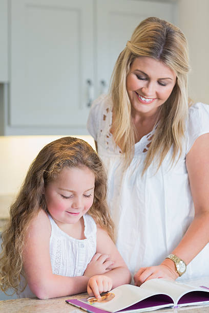 istock Happy mother helping daughter with reading 462634195