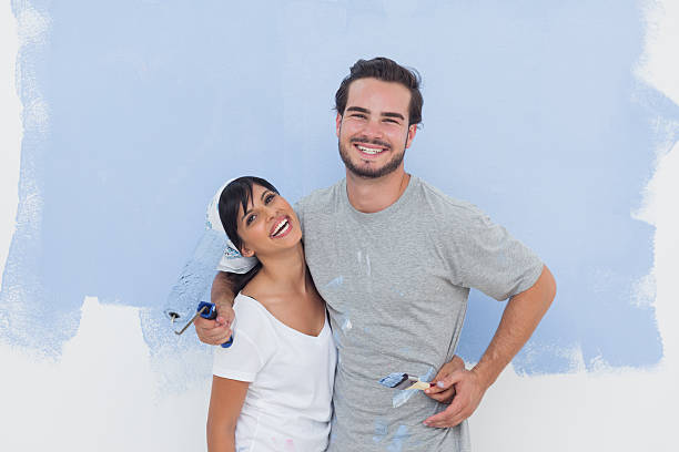 istock Couple in front of their blue wall laughing together 462637649