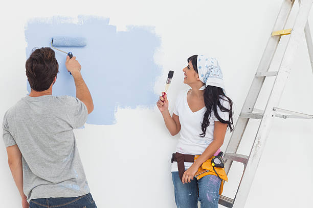 istock Couple painting their wall in blue 462637713