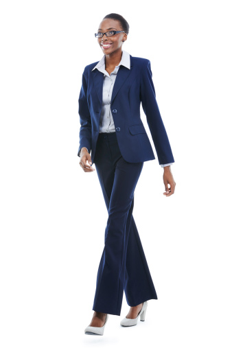 Full length studio shot of an african american businesswoman walking happily isolated on white