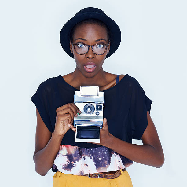Portrait of a trendy young ethnic woman capturing a photograph