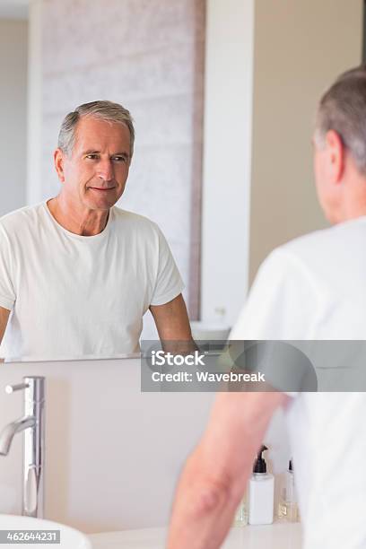 Lächelnd Reifer Mann Blick Auf Seine Reflexion Im Spiegel Stockfoto und mehr Bilder von 60-69 Jahre