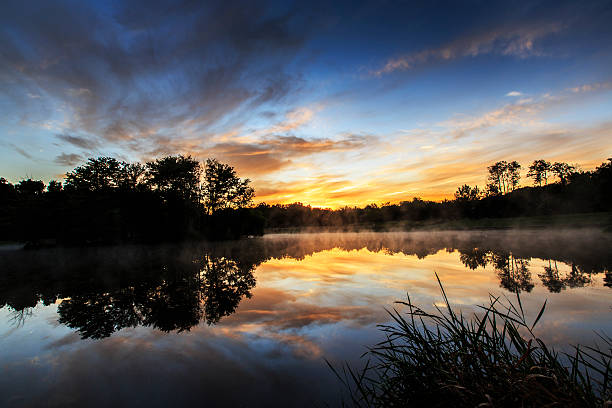 istock Sunrise clouds reflection and mist on a lake 462648875