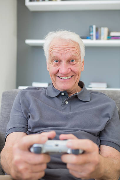 istock Smiling mature man playing video games 462648891