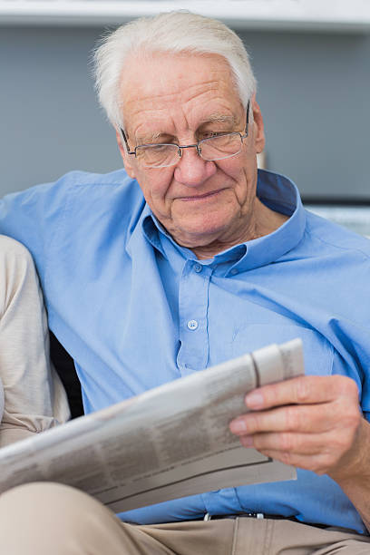 maduro hombre leyendo el periódico - newspaper glasses the media reading fotografías e imágenes de stock