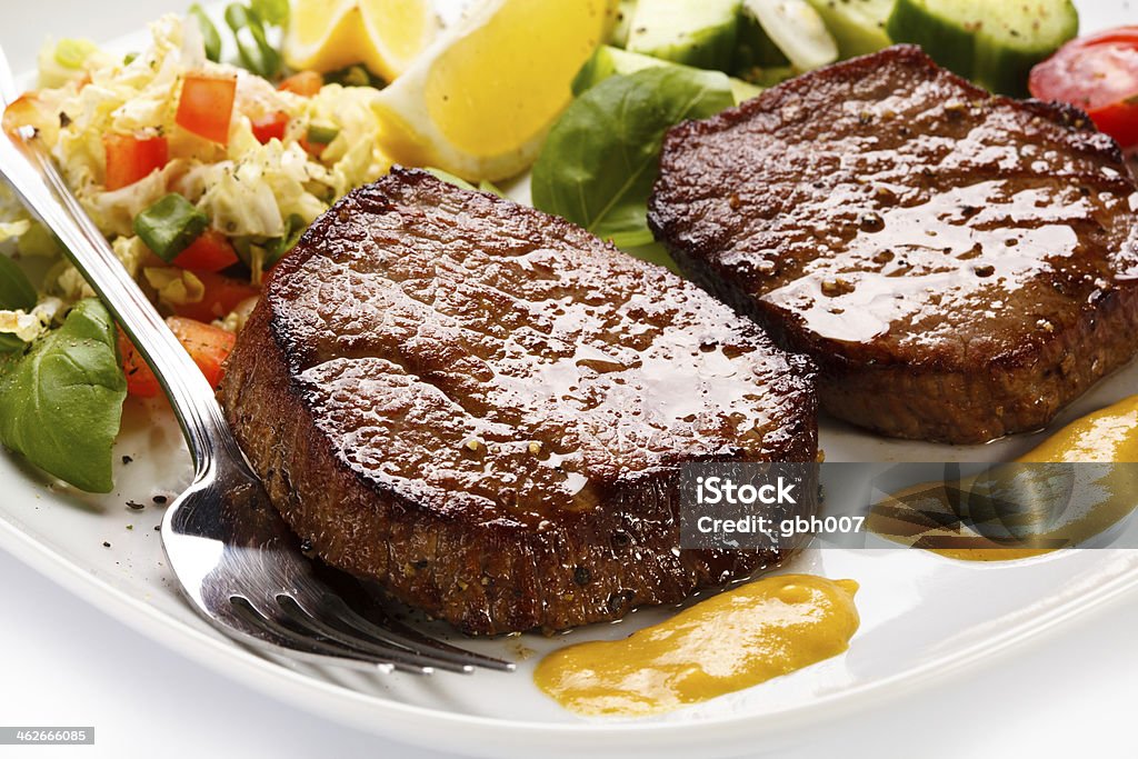 Grilled meat, potatoes and vegetables Grilled steak, baked potato and vegetables Basil Stock Photo