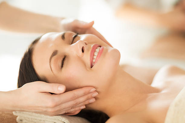istock happy woman in spa salon getting face massage 462667019