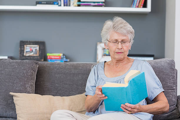 istock Concentrated mature woman reading on her sofa 462672521