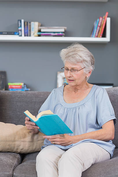 istock Mature woman reading on her sofa 462674719