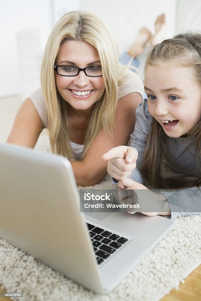Madre e hijo mirando a la computadora portátil - Foto de stock de 30-39 años libre de derechos