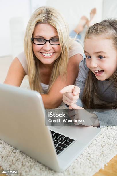 Madre E Hijo Mirando A La Computadora Portátil Foto de stock y más banco de imágenes de 30-39 años - 30-39 años, Acostado, Adulto