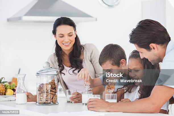 Familia Comiendo Galletas Y Leche Foto de stock y más banco de imágenes de 20 a 29 años - 20 a 29 años, Adulto, Adulto joven