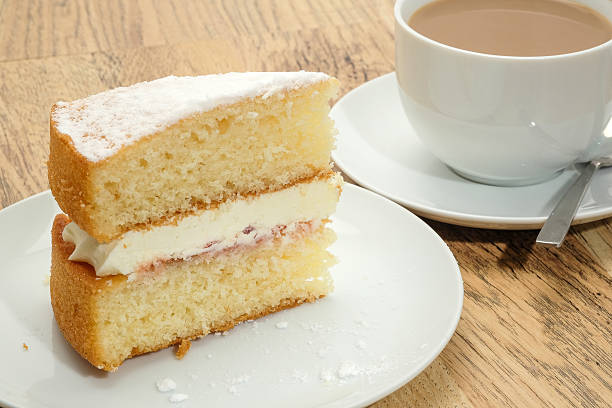 A slice of Victoria sponge cake with a hot drink