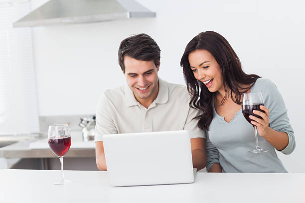 istock Couple using laptop while holding a glass of red wine 462679677