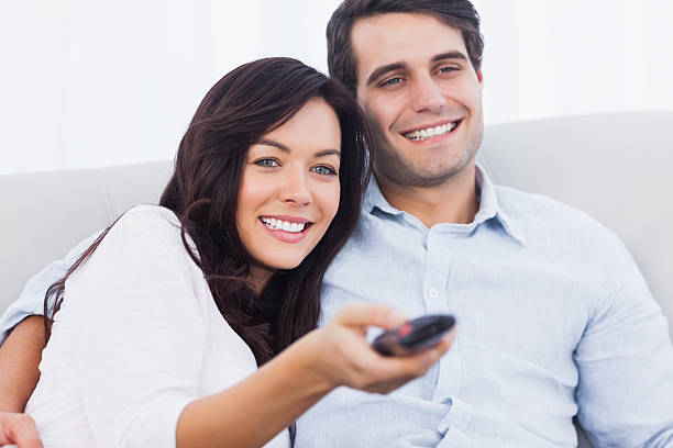 istock Woman changing tv channel sitting on a couch 462680343